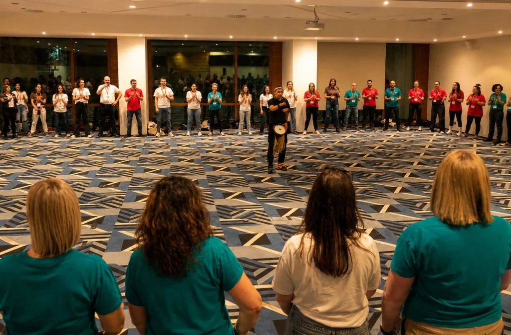 Equipo en círculo dando palmadas con un dinamizador en el centro en un taller de percusión corporal